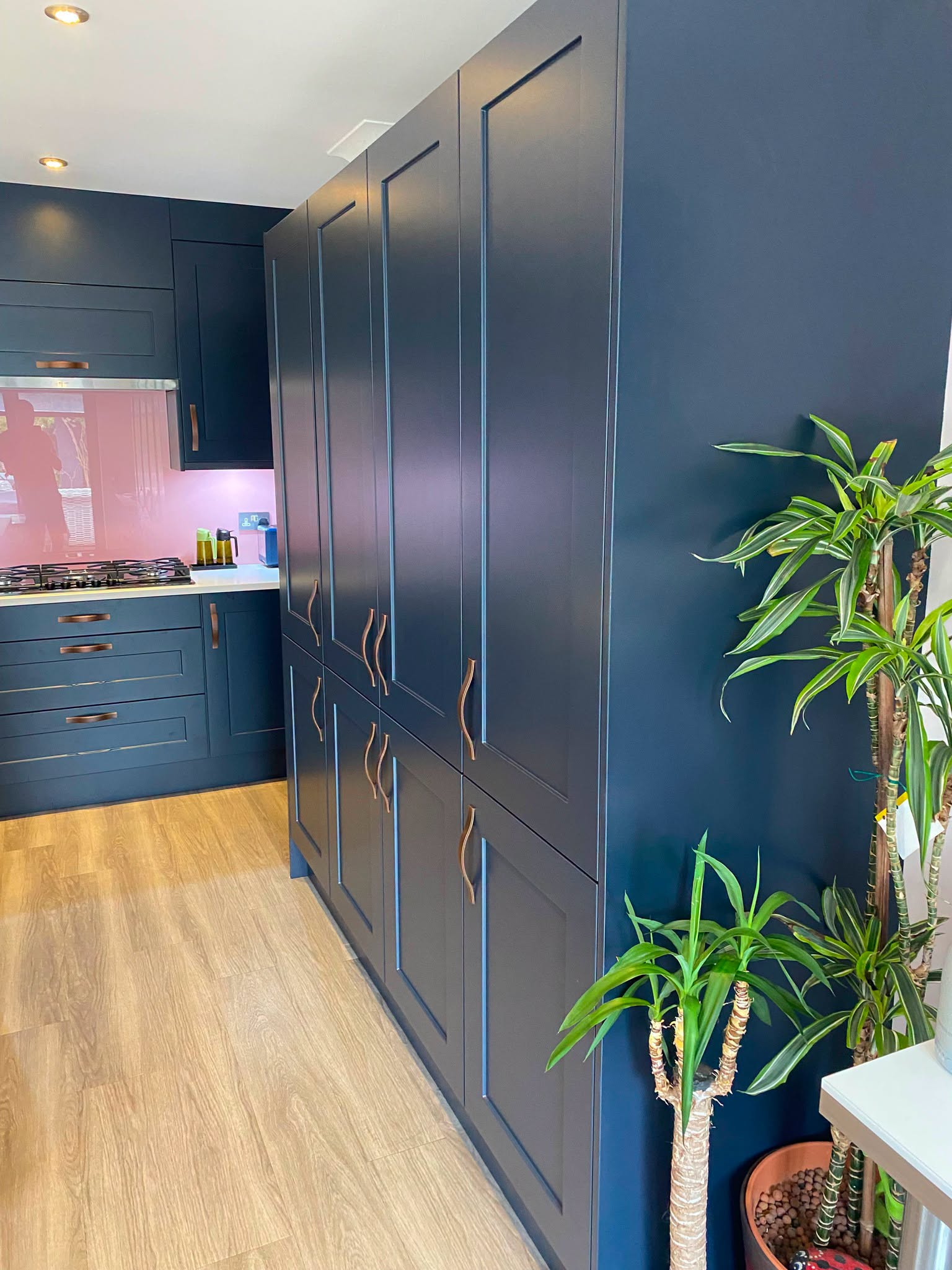 Run of tall indigo shaker larder units with brass handles