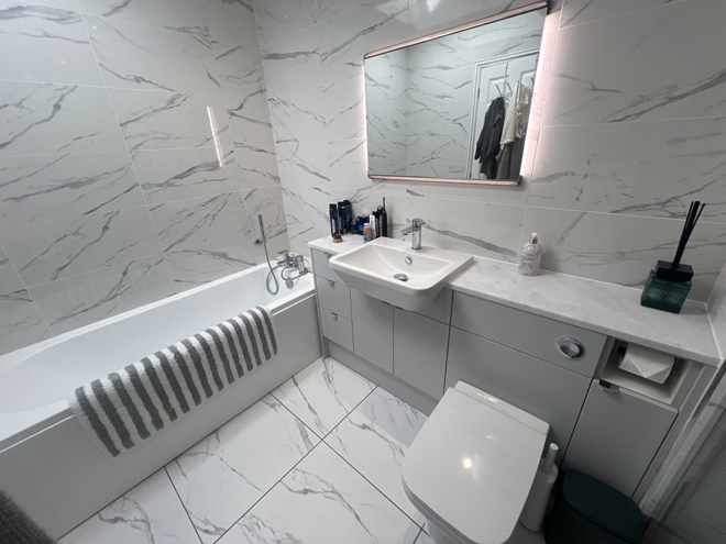 Bath and vanity in a marble-tiled en suite