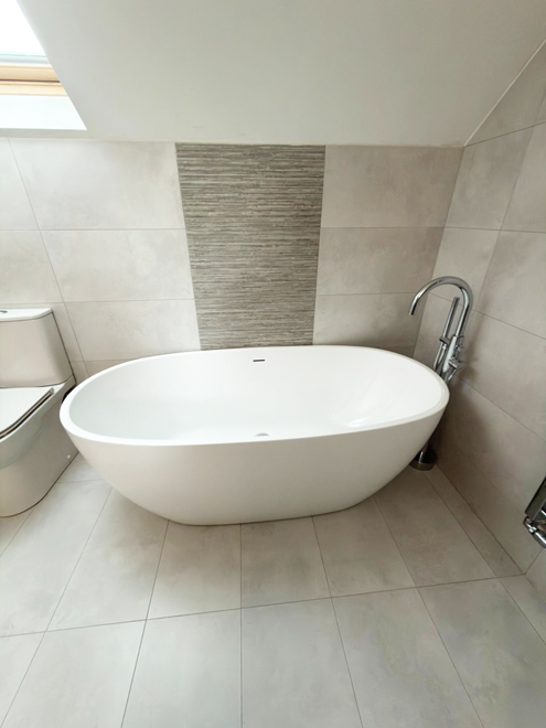 Freestanding bath beside a textured feature wall