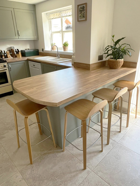Oak breakfast bar with stools in a French grey kitchen