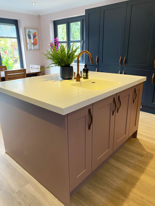 Dusky pink island with drawers and a white quartz top