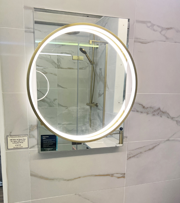Brushed brass round illuminated mirror in our Chic display