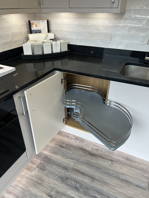 Matt cashmere slab door kitchen display with a corner carousel